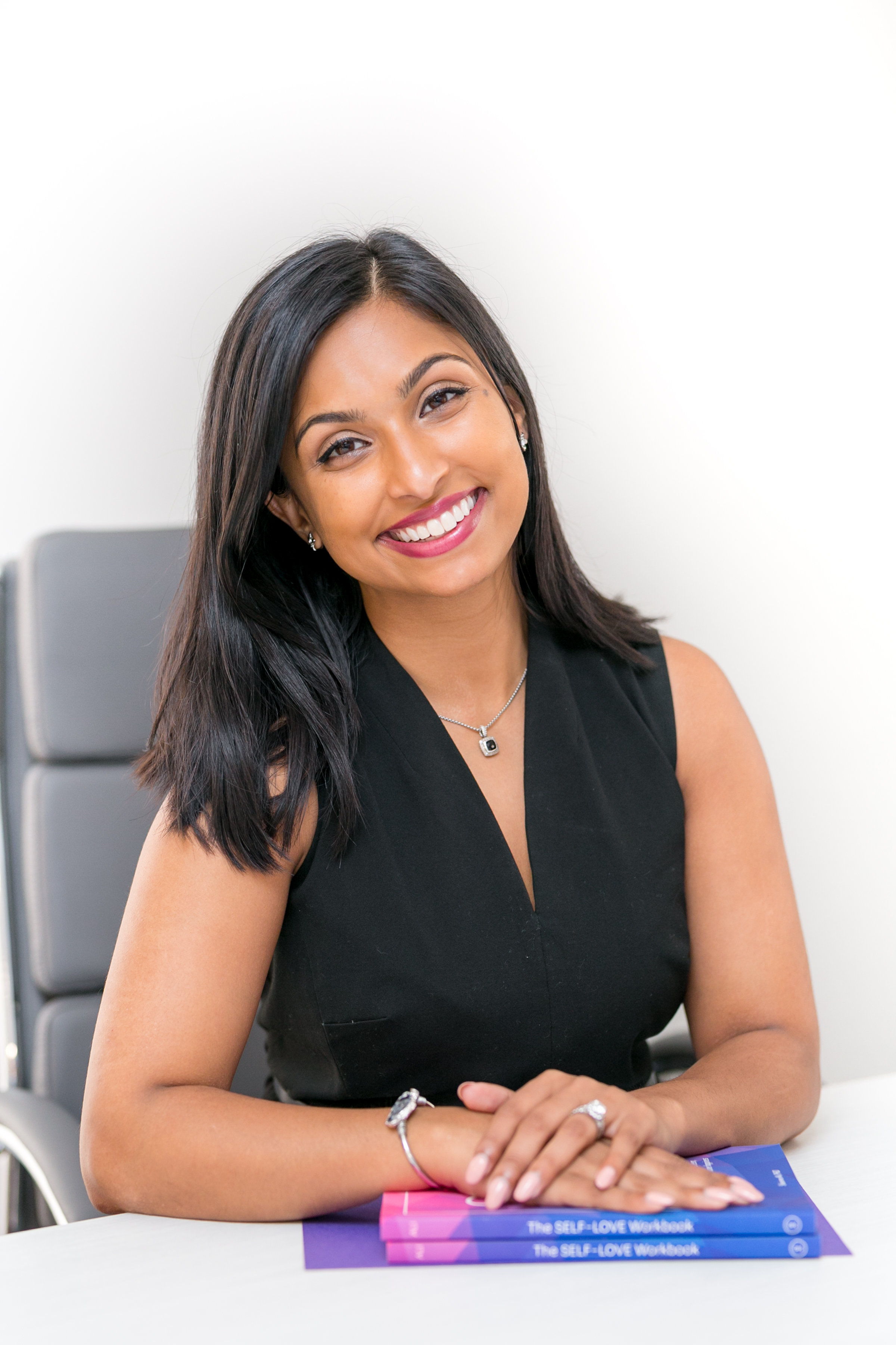 Dr. Shainna Ali professional headshot with books