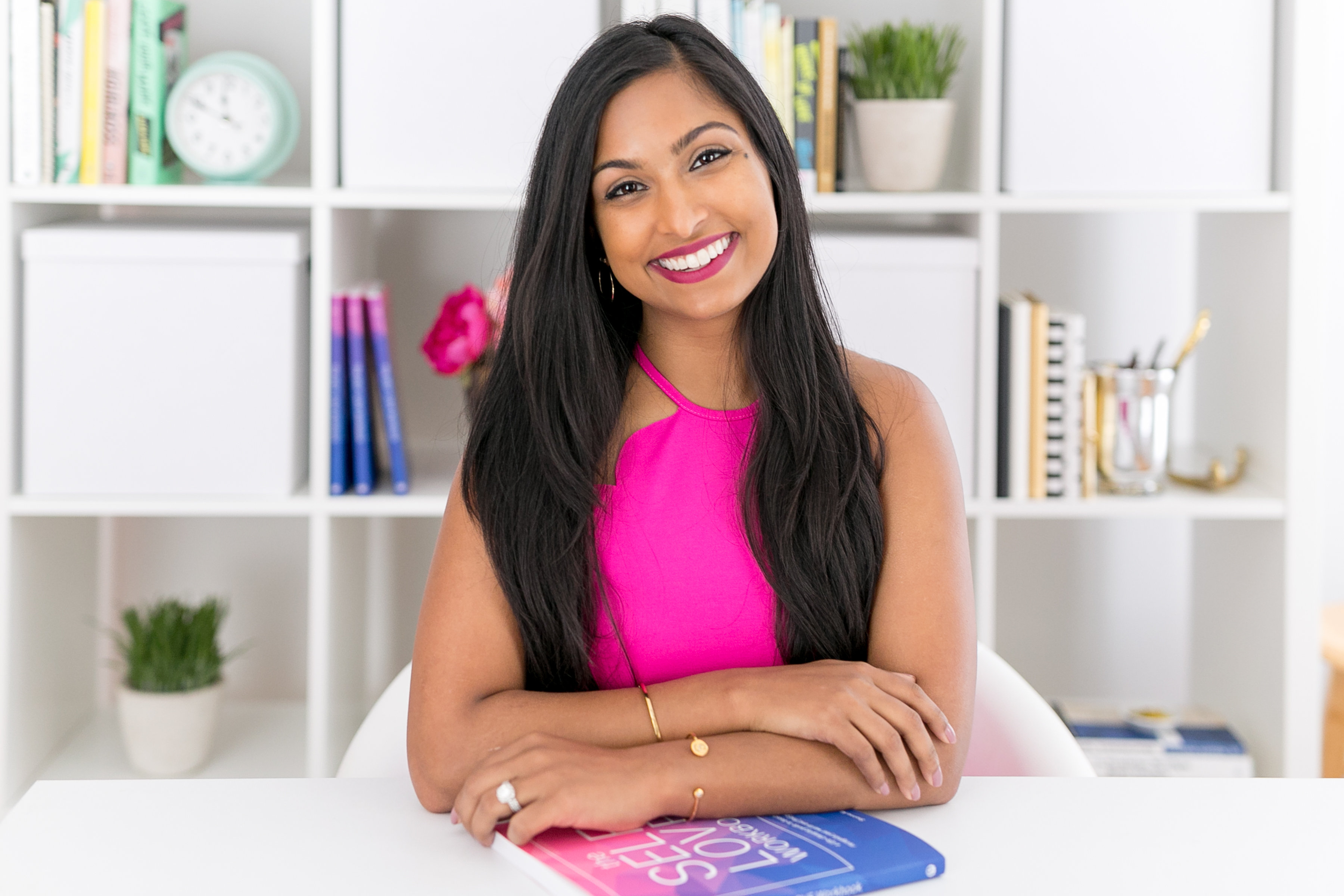 Dr. Shainna Ali at bookshelf with workbooks